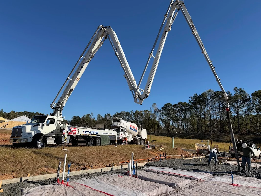 Concrete pump truck positioning boom to pour a residential house slab.