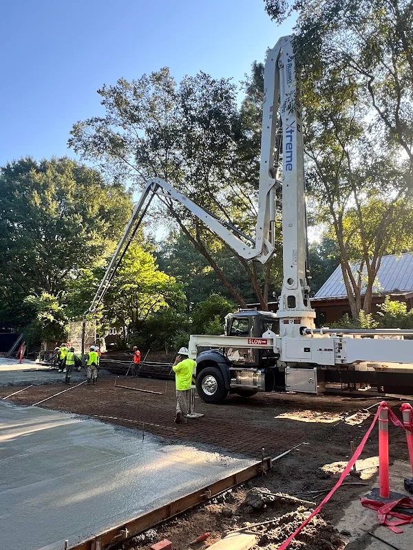 Professional concrete pump truck operator setting up equipment at a job site.